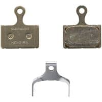 Shimano K05S-RX steel back resin disc pads with spring, featuring a metallic finish and compact design.