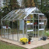 Greenhouse with toughened glass, silver aluminum frame, pitched roof, and sliding door, surrounded by plants.