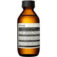 Amber bottle of Aesop In Two Minds Facial Cleanser, black cap, white label with black text, 100ml.