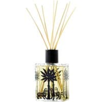 Clear glass diffuser with black palm tree design, filled with yellow liquid and reed sticks, by Ortigia.