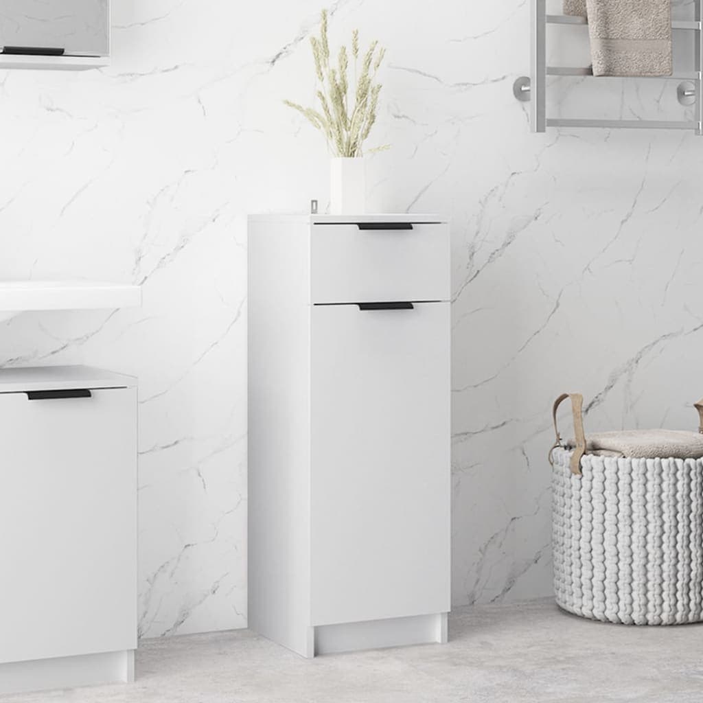 White bathroom cabinet made of engineered wood, featuring two drawers with black handles, set against a marble wall, with a decorative plant on top.