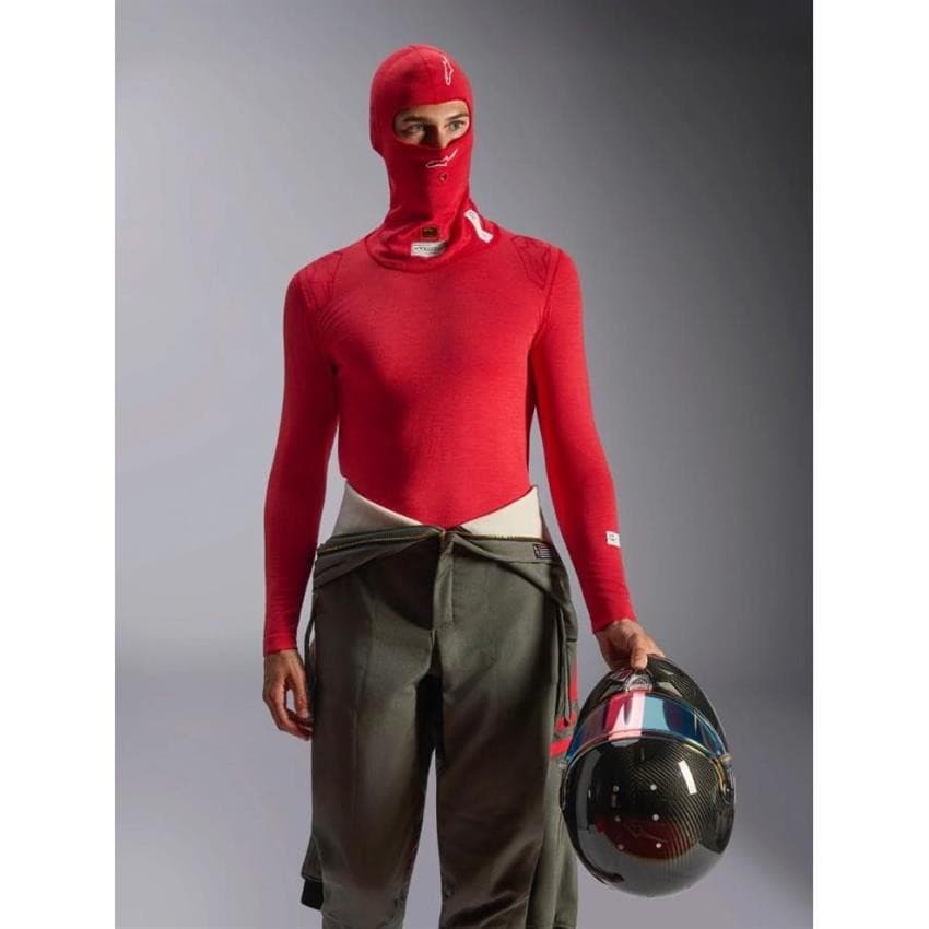 Red FIA/SFI race head sock featuring a full-face design, made of breathable material, with a snug fit, worn by a person holding a helmet, showcasing racing gear.