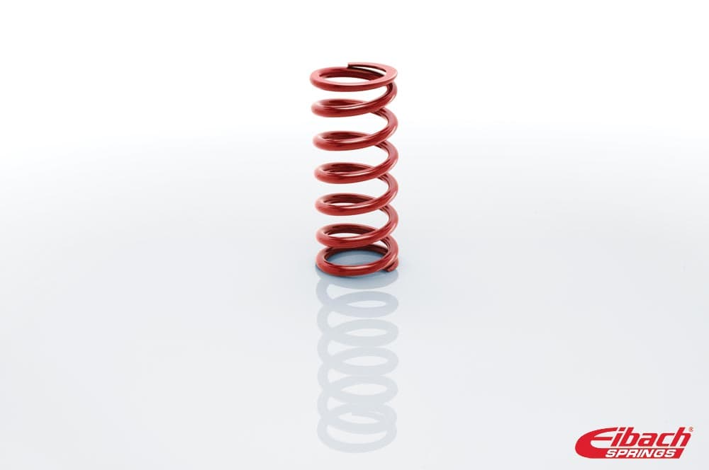 Red coil over spring by Eibach, measuring 2.5 inches in diameter and 8 inches in height, with a smooth metal finish and distinct spiral design.