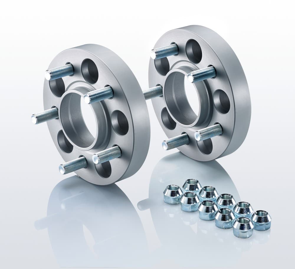 Silver aluminum track widening spacers with five holes each, featuring threaded bolts, accompanied by chrome wheel nuts, designed for a 15mm width increase per side.