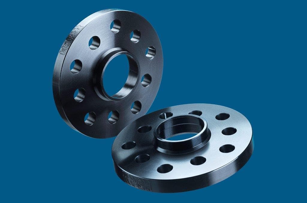 Black aluminum H&R B2055668 Track Widening TRAK+® wheel spacers, 10mm thick, featuring 5 holes and a central hub, designed for increased track width per axle.
