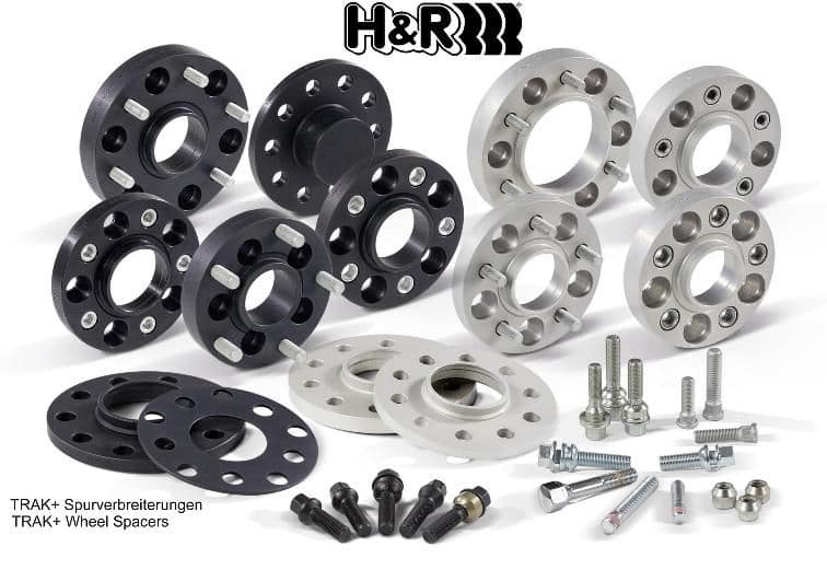 Black and silver H&R TRAK+® wheel spacers, 20mm thick, featuring 4 holes, accompanied by bolts and accessories, designed for track widening of 40mm per axle.