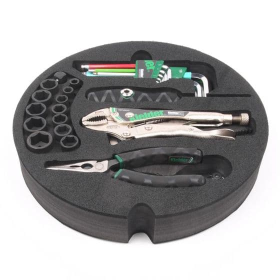 Kielder Layer Cake Hand Tool Kit in a black circular case, featuring silver pliers, black-handled tools, and various hex keys and sockets neatly organized in foam.