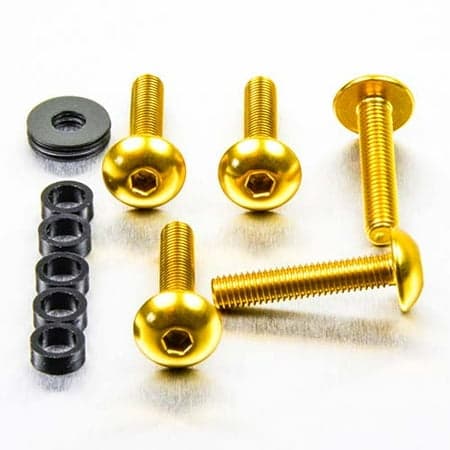 Gold dome head alloy bolts with M5 x 0.80mm x 11mm x 25mm specifications, accompanied by black washers and spacers, arranged on a metallic surface.