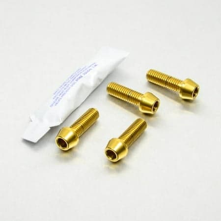 Gold stainless steel bottom clamp yoke pinch bolt kit by Pro-Bolt, featuring four gold bolts and a small tube of adhesive.