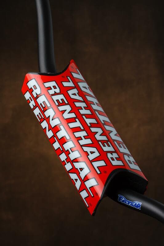 Red Renthal Team Issue Fat Bar handlebar pad featuring bold white "RENTHAL" logos, designed for added grip and protection, made from durable material.