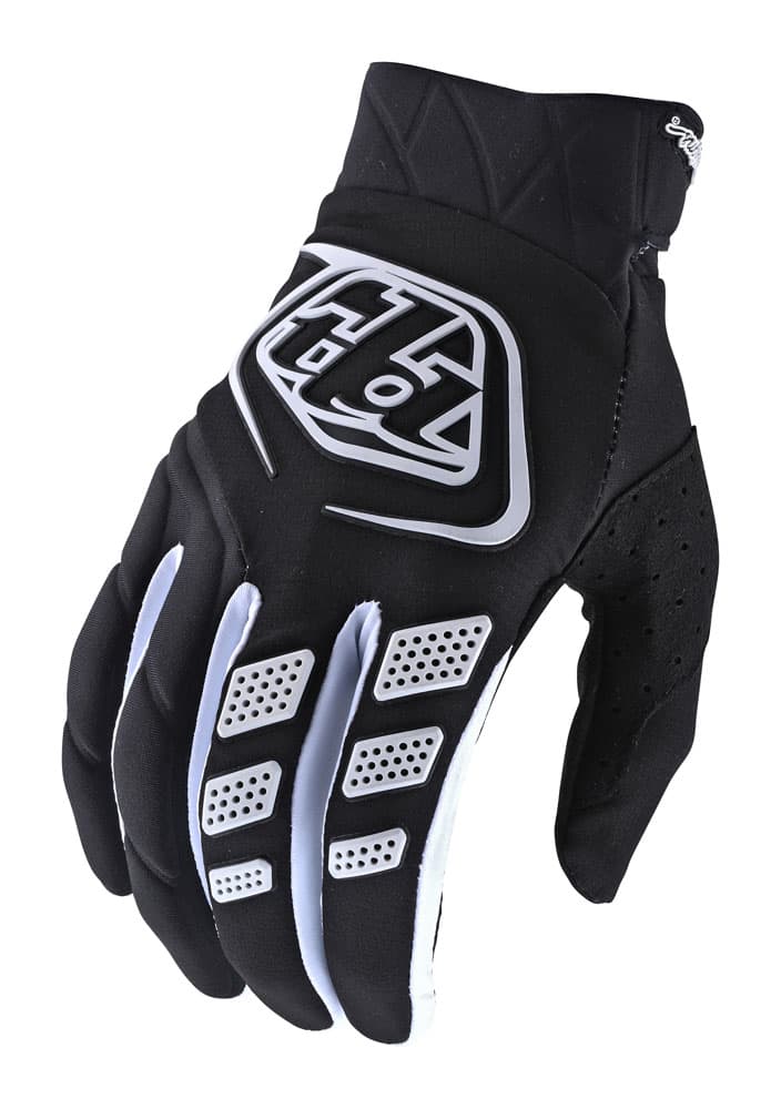 Black textile gloves featuring a white Troy Lee Designs logo, padded fingers, and perforated sections for breathability, designed for optimal grip and comfort.