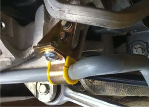 Heavy-duty adjustable sway bar in grey, featuring a yellow bushing and metal brackets, designed for Mitsubishi Lancer Evo models.