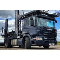 Black Scania truck with 420 brake horsepower, large cab, and trailer, set against a cloudy sky backdrop.