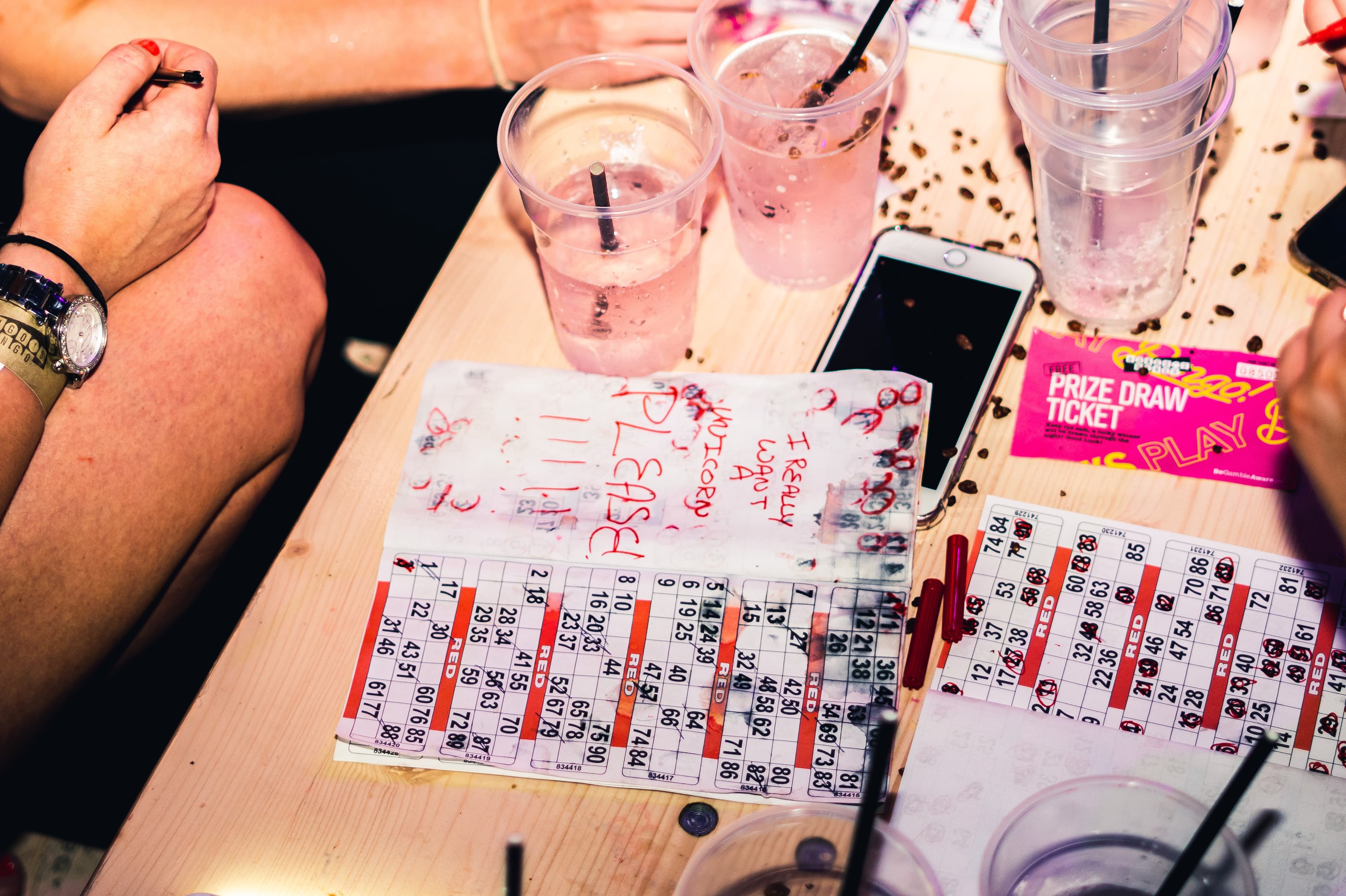Colorful bingo cards and drinks on a table, with festive decorations, capturing the lively atmosphere of Bongo's Bingo in Leeds.
