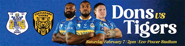 Three rugby players in blue and yellow kits stand confidently against a vibrant background, promoting the Dons vs Tigers match.