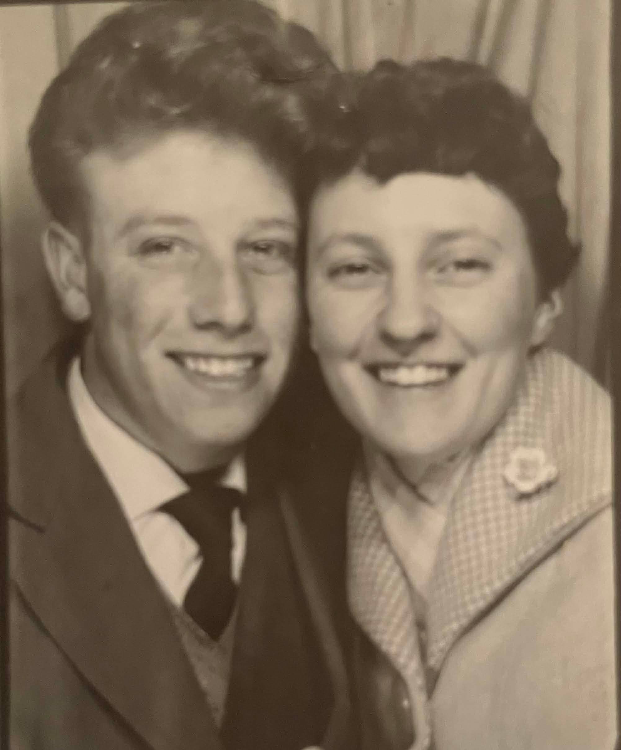 A smiling couple in vintage attire, celebrating their love, with a warm, nostalgic atmosphere.
