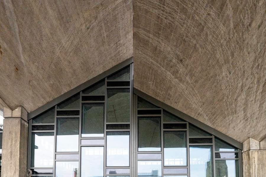 Modern architectural structure with a striking angular design, featuring large glass windows and textured concrete in Huddersfield.