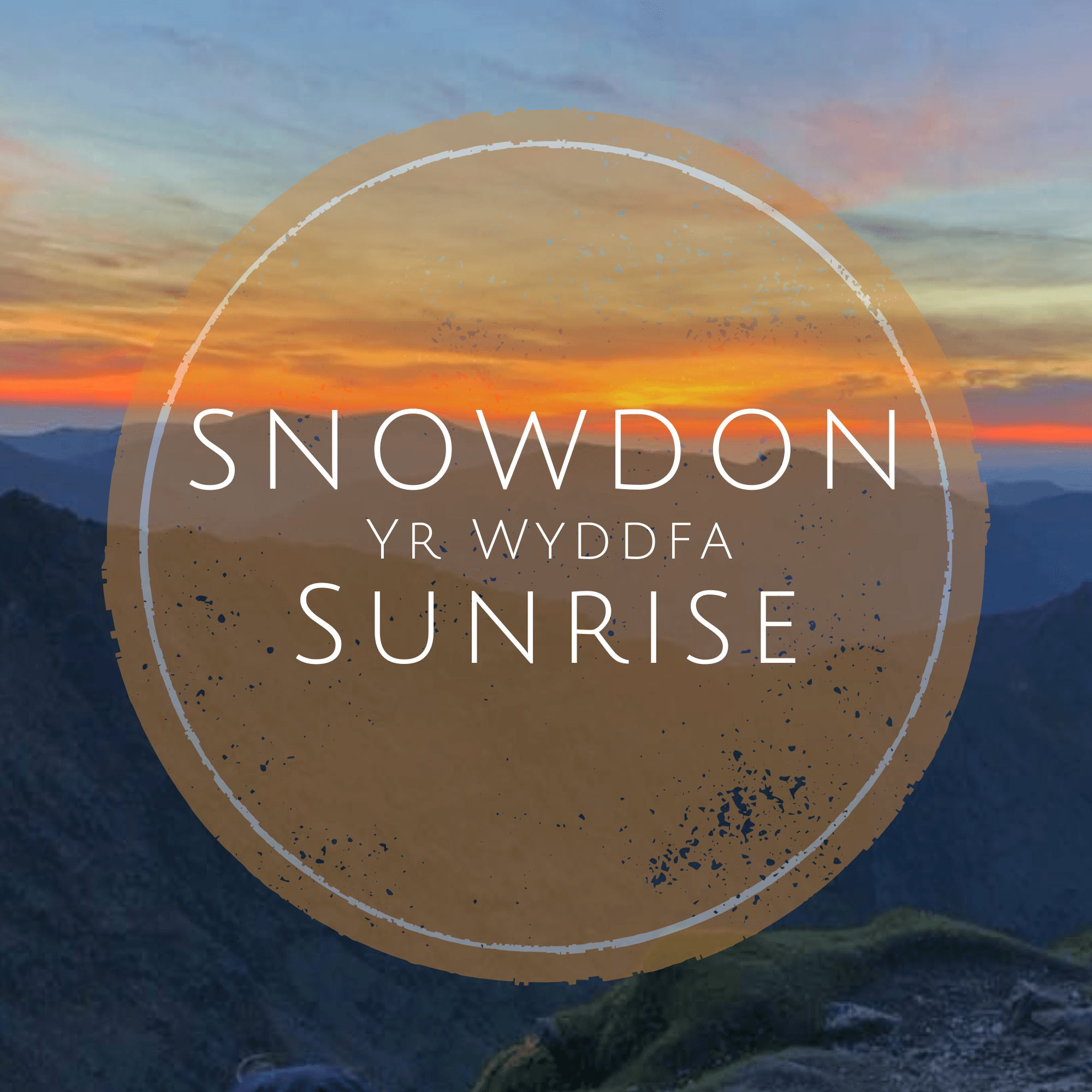 Stunning sunrise over Snowdon, casting vibrant colors across the mountainous landscape, creating a serene atmosphere.