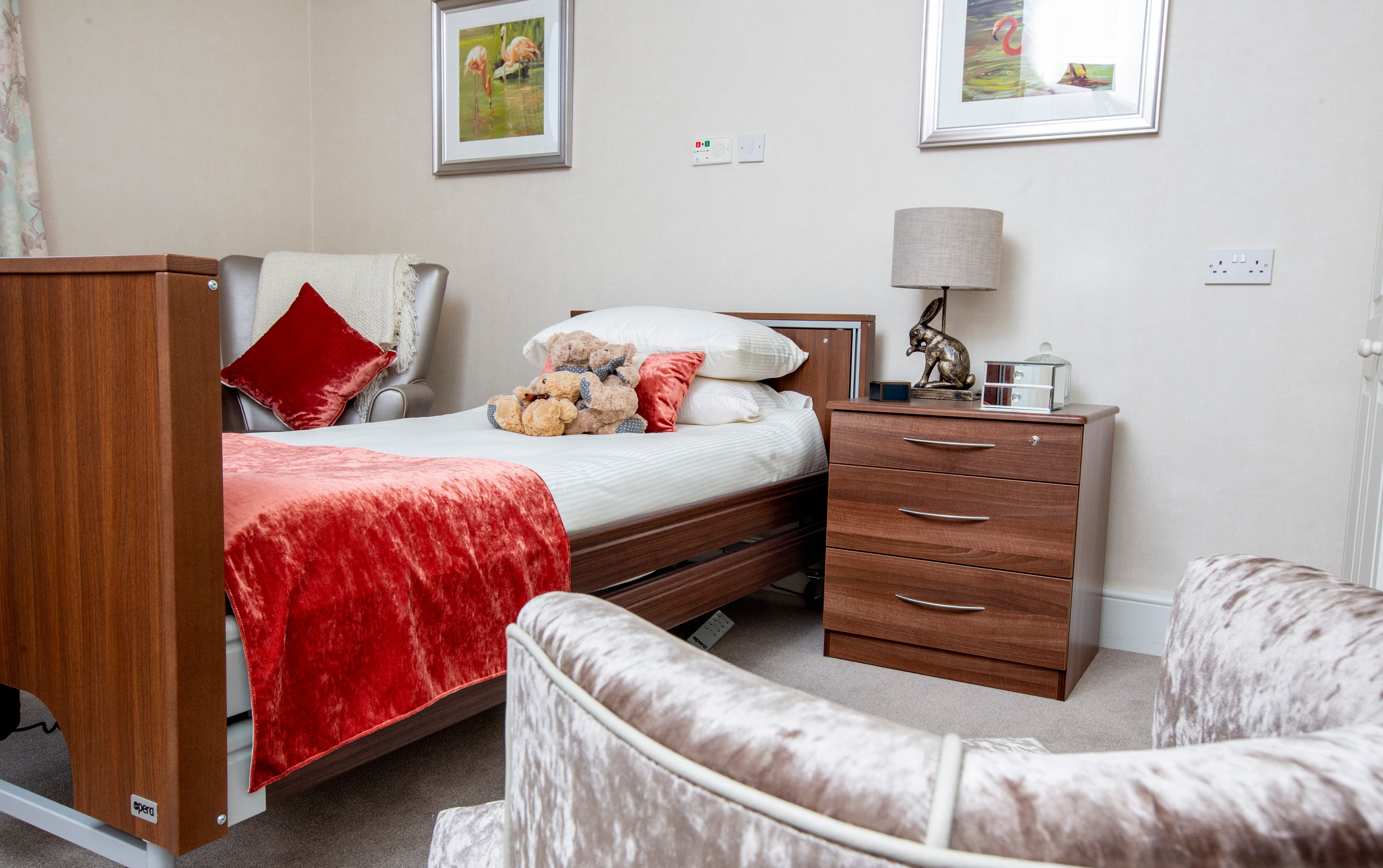 Cozy respite room featuring a bed with plush toys, soft furnishings, and warm decor, promoting comfort and relaxation.