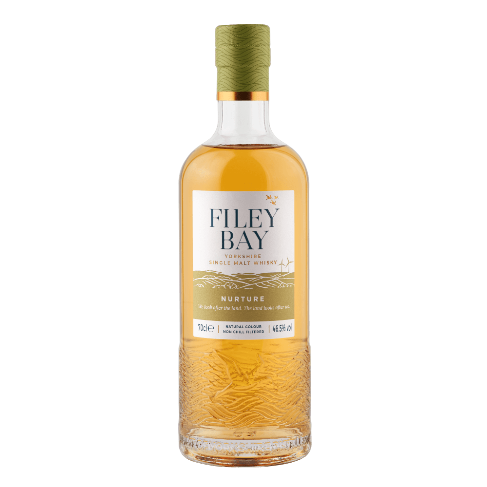 A bottle of Filey Bay Nurture single malt whisky with a golden hue, featuring a textured base and a green cork.