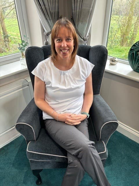 Smiling woman sitting on an armchair in bright room