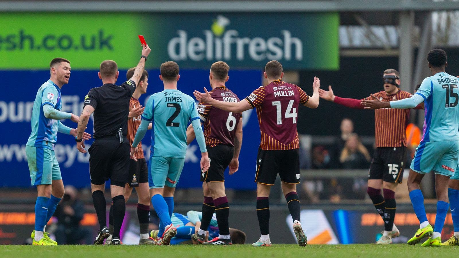 Football referee showing red card to player during match