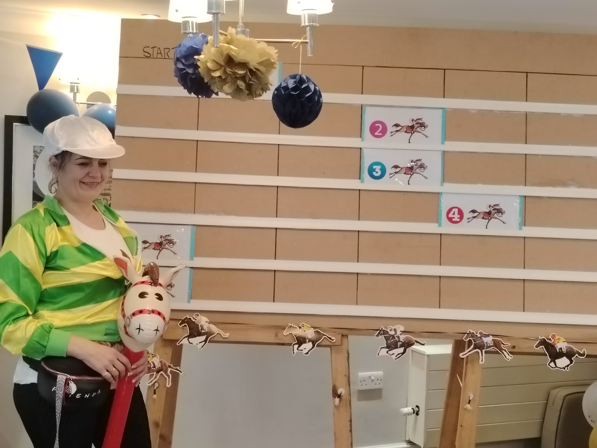 Person in jockey costume by race-themed game board