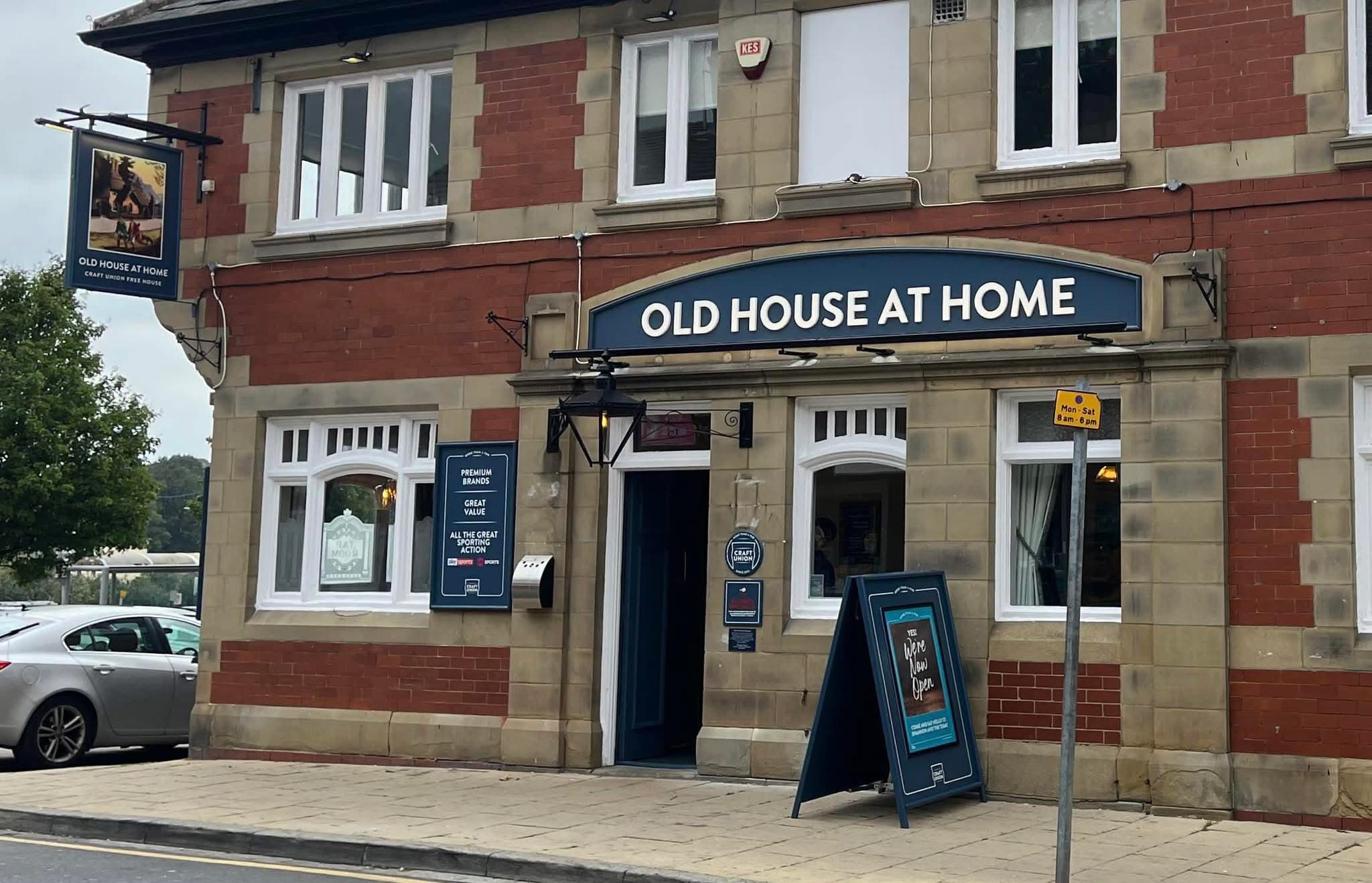 Traditional brick pub with blue signage and menu boards