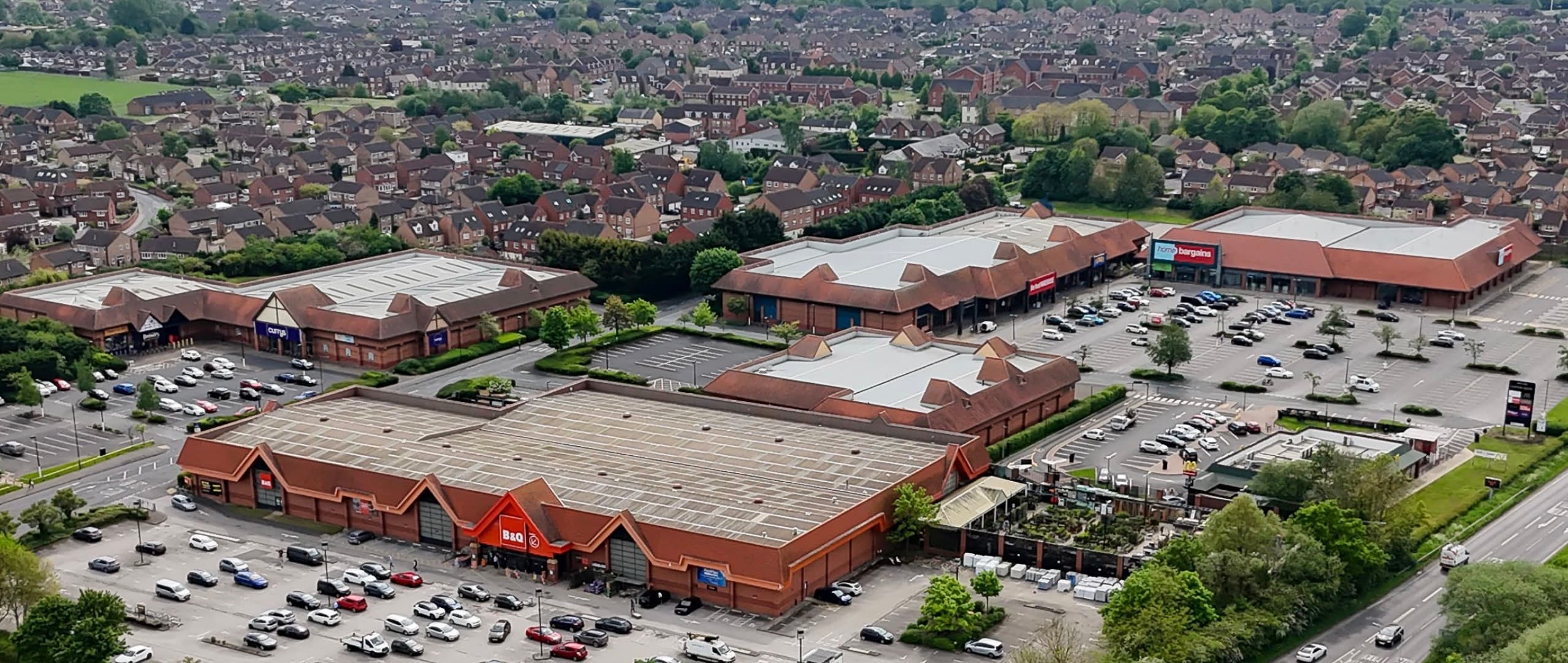 Aerial view of large shopping complex with red brick buildings