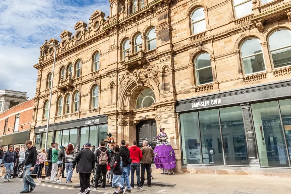 Victorian stone building with ornate facade on busy street