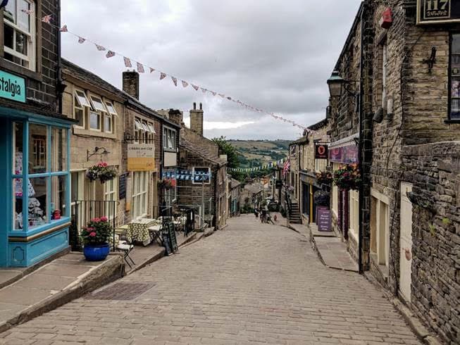 Cobblestone street in Haworth with shops and bunting