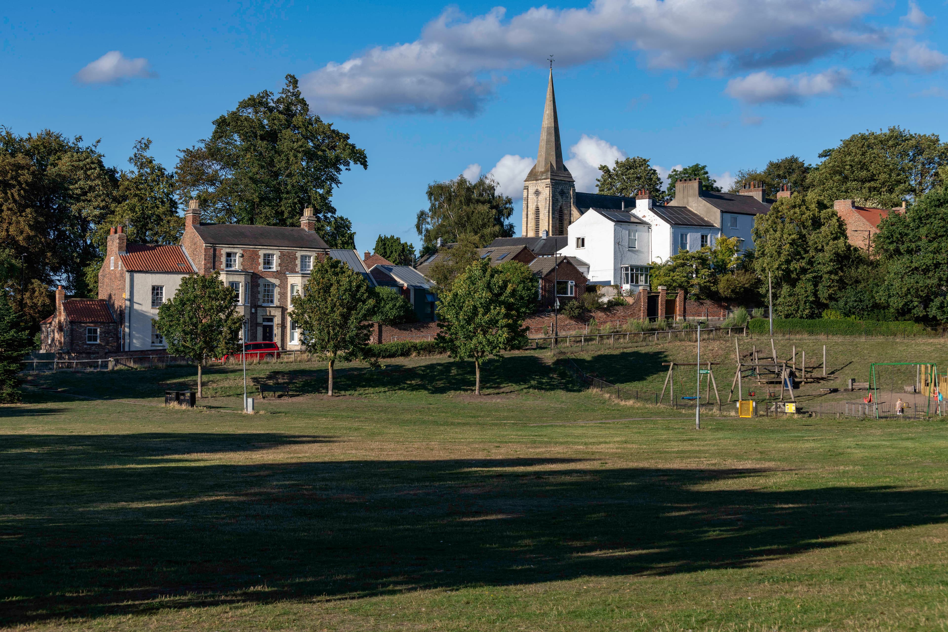 Quaint Yorkshire village with church spire and green field