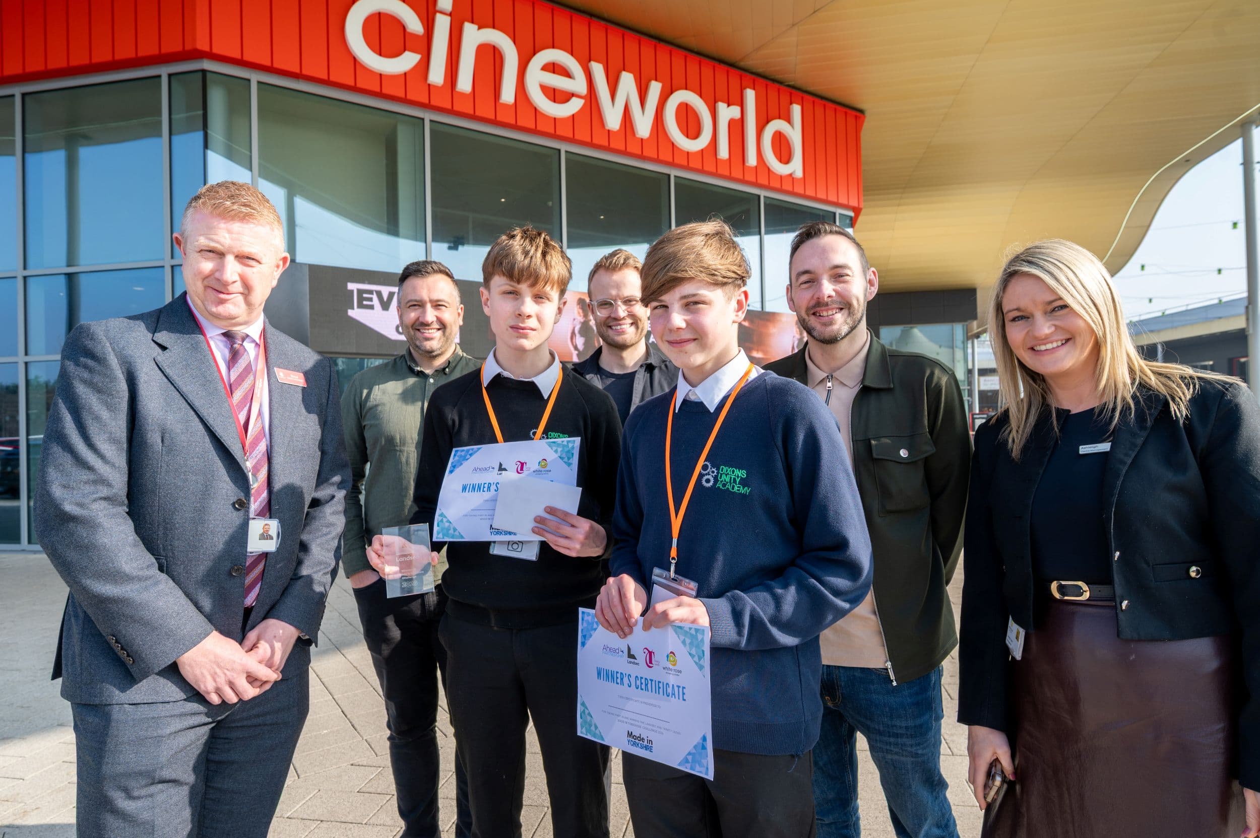 Group of people smiling outside a Cineworld cinema entrance