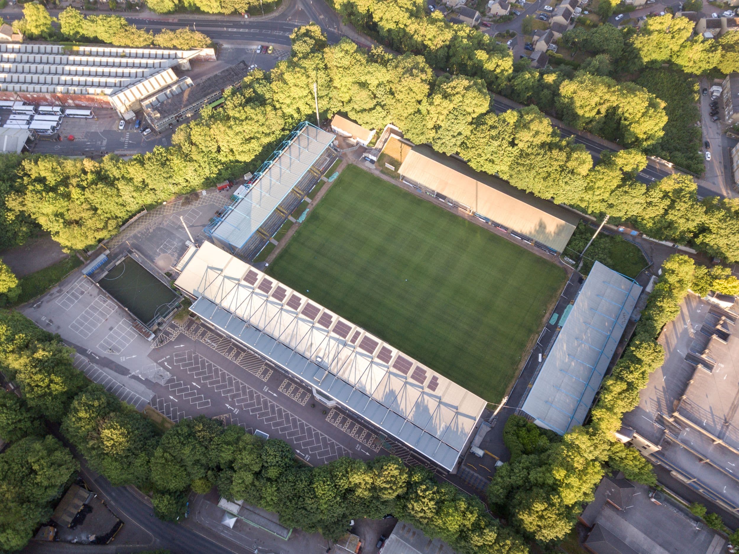 Aerial view of football stadium surrounded by trees and parking