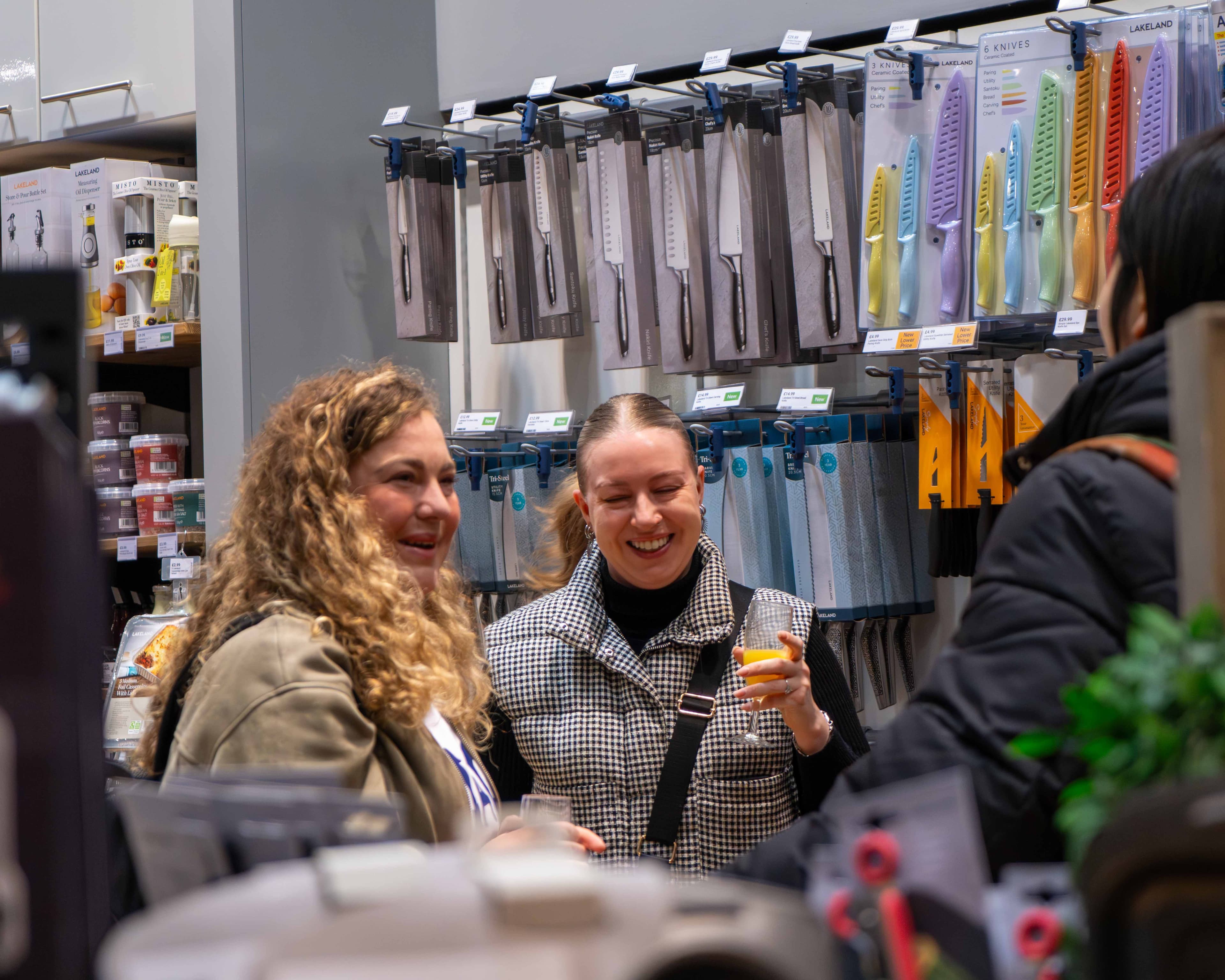 Two women smiling while shopping for kitchen knives