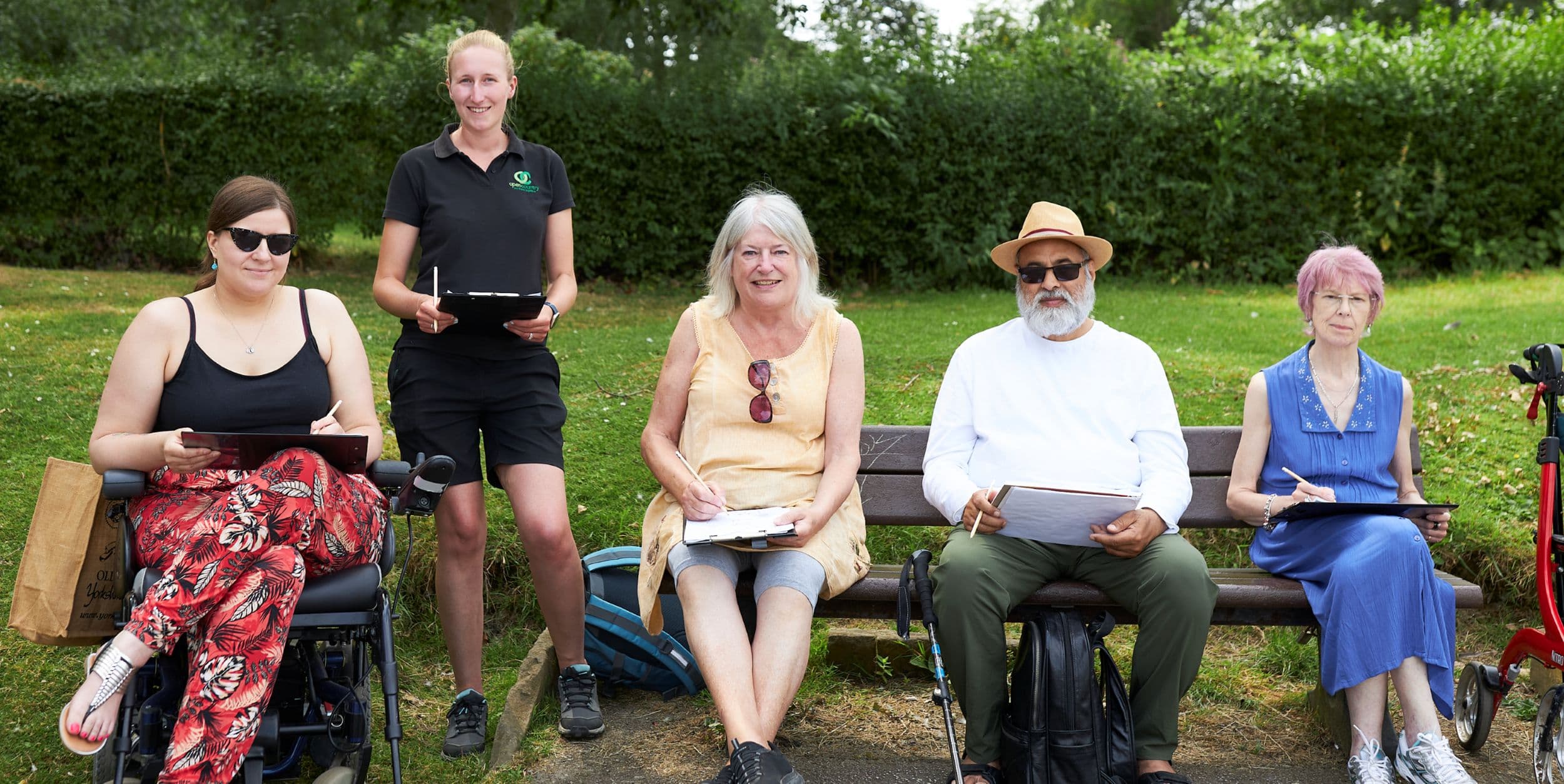 Group of people sitting on a park bench enjoying a sunny day