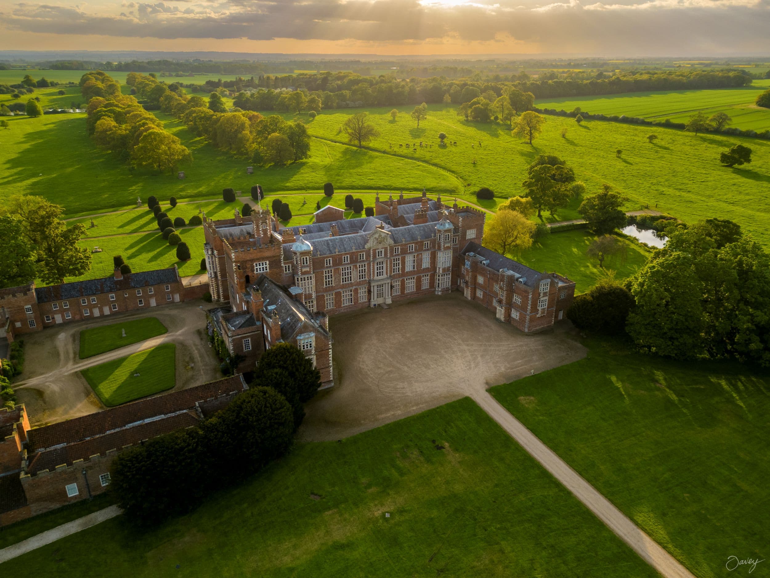 Aerial view of Burton Constable Hall surrounded by lush green fields