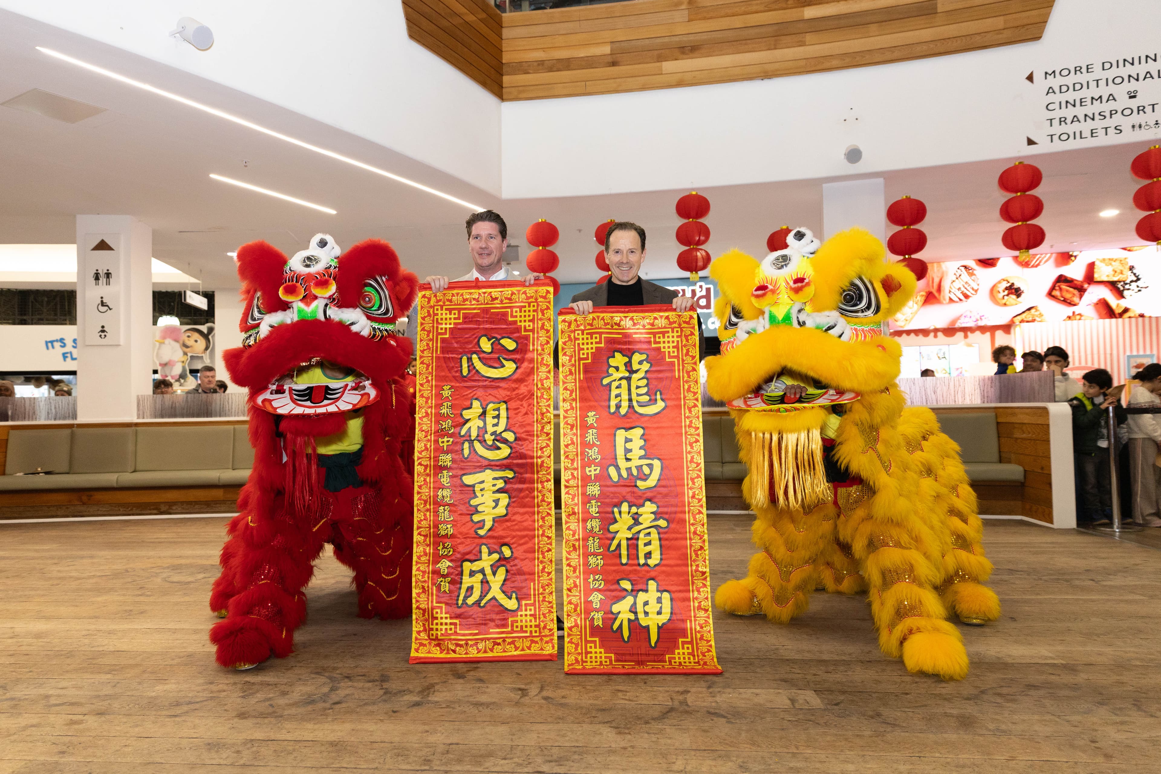 Two vibrant lion dance costumes in a modern indoor setting