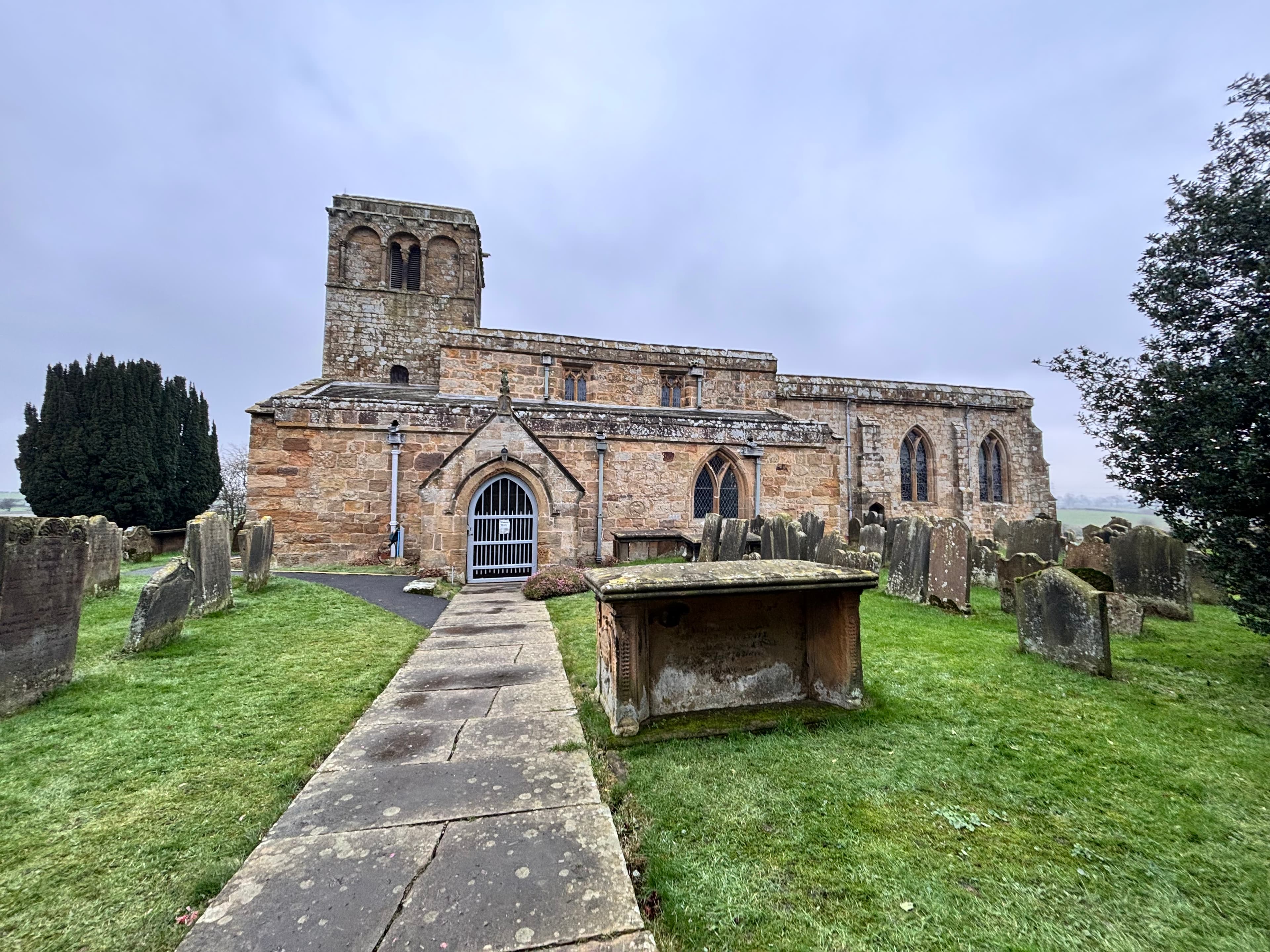 Medieval stone church with arched windows and graveyard