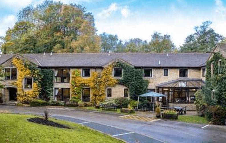 Charming stone hotel with ivy-covered walls in lush garden
