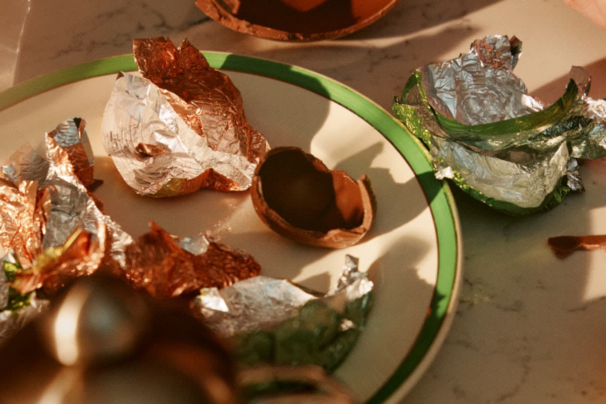 Colorful foil wrappers and chocolate eggshells on a plate