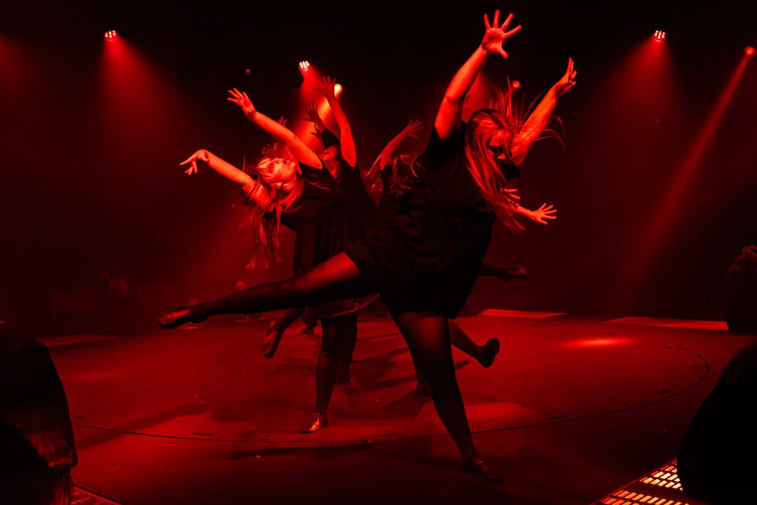 Contemporary dance performance with dynamic red lighting