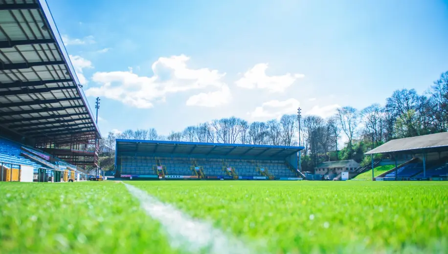 Sunny day at an empty football stadium with green field