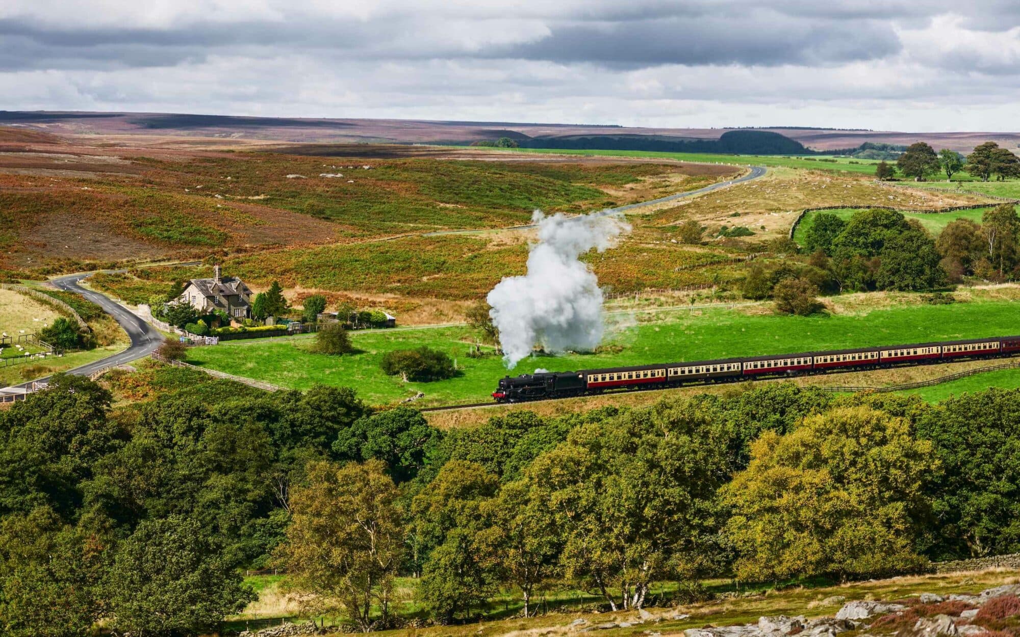 a train in the countryside of North Yorkshire Moors Railway