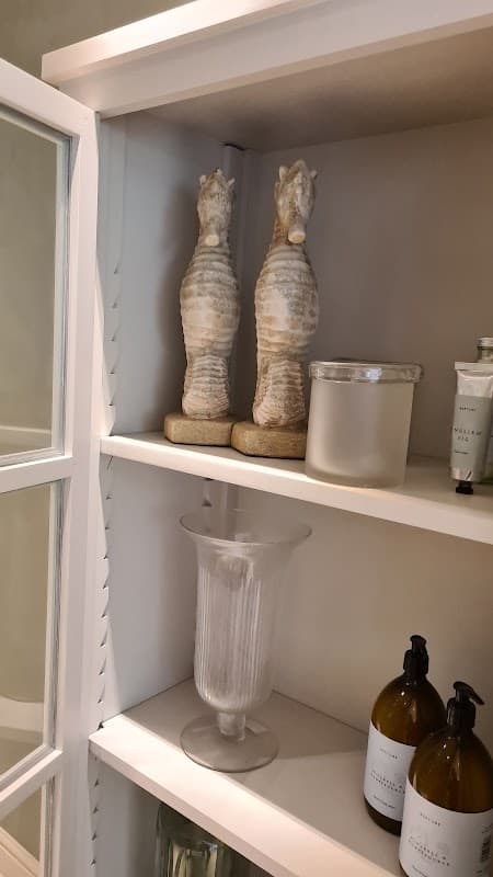 Decorative shelves featuring seahorse sculptures, a glass vase, and bottles of toiletries in a cozy interior setting.