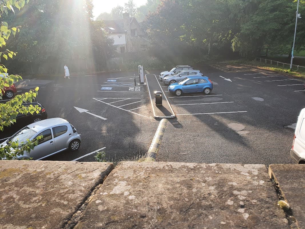Bell Lane Car Park with 36 spaces, featuring several parked cars and green trees in the background.