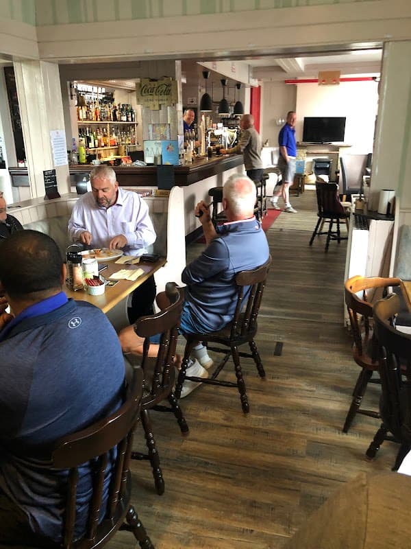 Cozy cafe interior with patrons at tables, a bar with drinks, and a relaxed atmosphere in Addingham, Yorkshire.