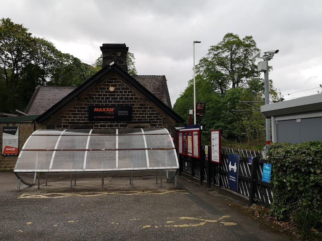 Pay & Display car park at Baildon Station with a stone building, ticket machine, and surrounding greenery.