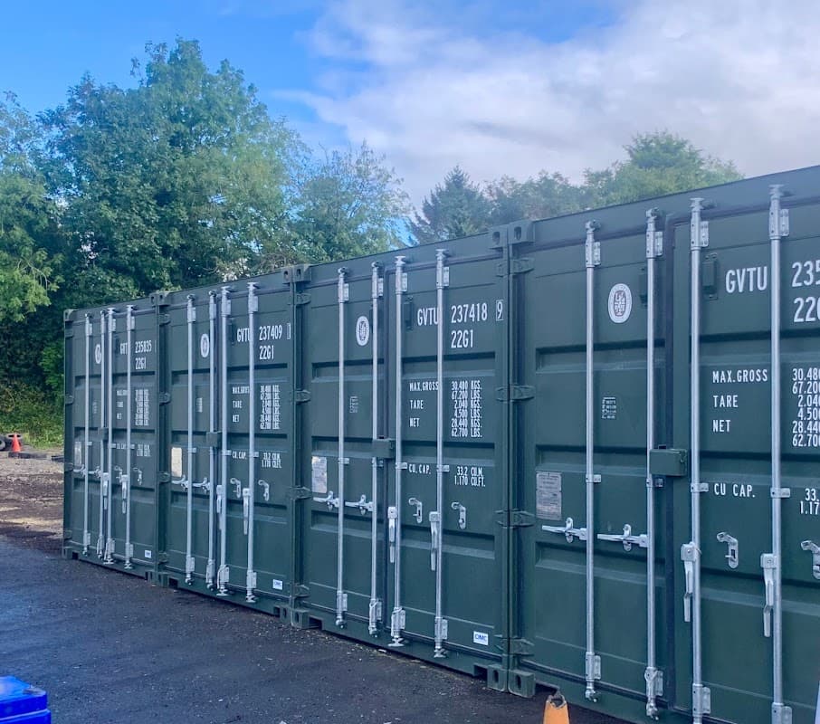 Storage containers lined up outdoors, surrounded by trees and a cloudy sky in Balby, Yorkshire.
