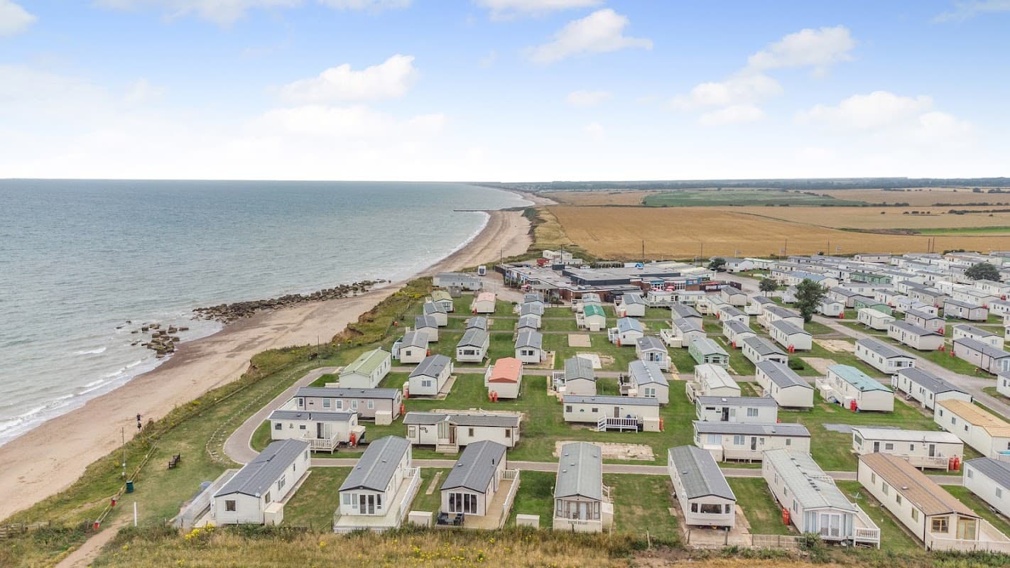 Aerial view of Parkdean Resorts Barmston Beach with caravans, sandy beach, and coastline in Yorkshire.